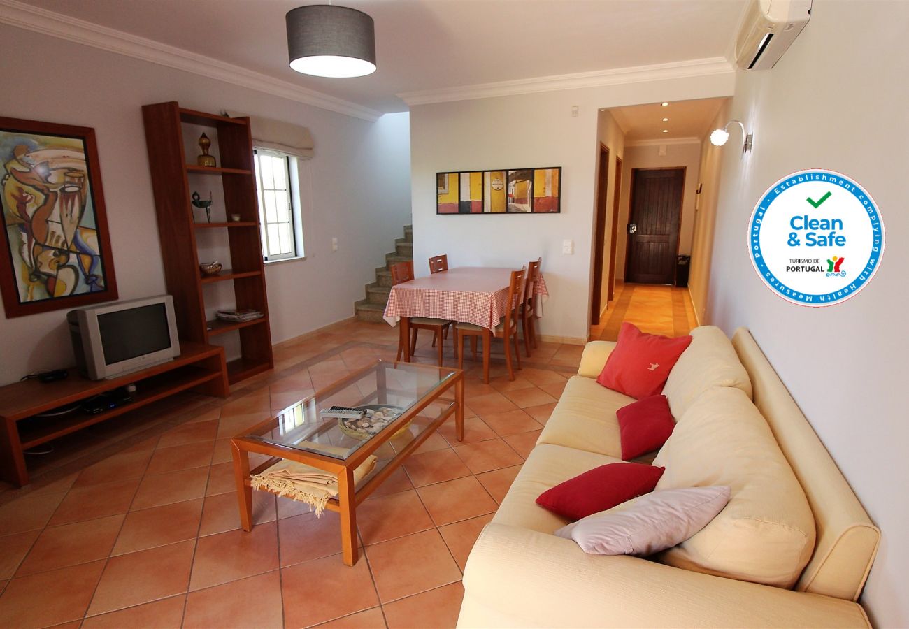 Living room with sofa, dining table, TV, coffee table, air conditioning.